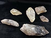 Six smoky quartz crystals on black fabric