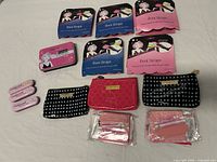 All items laid out: five boot strap packages, emergency kit, three fashion tape packs, three accessory pouches with travel packets