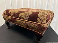 Side view showing damask fabric, leather piping, cabriole legs