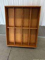 Front view of wooden shelf showing eight compartments