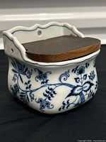 Front view showing Blue Onion pattern and wooden lid
