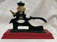 Right side view of cast iron soldier nutcracker on red wooden base