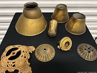 Group view of all brass and glass lighting parts on table