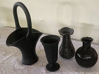 Front view of four black pottery pieces