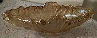 Side view of peach iridescent carnival glass gondola bowl