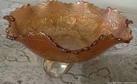 Top view of marigold carnival glass bowl showing ruffled rim and floral pattern