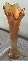 Full view of ribbed marigold iridescent vase standing upright