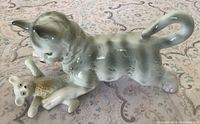 Left side view showing cat figurine with teddy bear