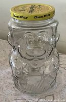 Front view showing Super Mario facial and body details, lid graphics visible