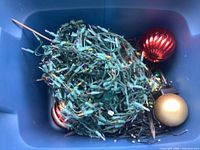 Tote with tangled green string lights and three large ornaments
