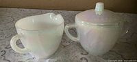 Creamer and sugar bowl with lid, front view showing shape and finish