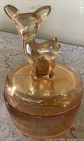 Front view of lidded powder dish with deer finial