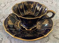 teacup on saucer showing front and interior gold filigree