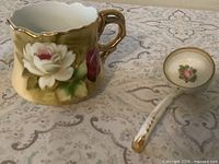 Cup and ladle front view showing floral designs