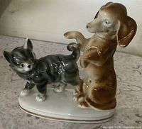 Front view of porcelain figurine showing dachshund and kitten interaction