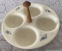 Top angled view showing four egg wells and wood handle