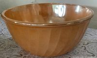 Side view of peach lustre Fire-King mixing bowl