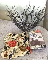Metal branch basket and packaged chair seat covers displayed together