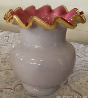 Side view of peach uranium custard vase showing amber crest and white exterior