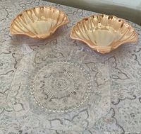 Group shot of two peach lustre shell dishes and clear square Columbia plate