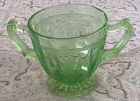 Front view of green uranium glass sugar bowl showing handles and pattern