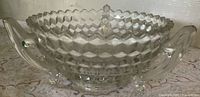 Side view of pressed glass bowl showing cube pattern, three handles and footed base