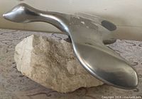 Top view of polished aluminum goose on stone base