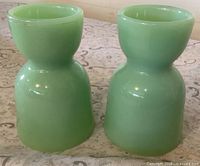 Front view of two green jadeite double-sided egg cups
