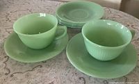 Two jadeite teacups and four saucers view