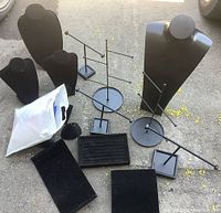 Group shot of necklace busts, T-bar stands, pads and tray on ground