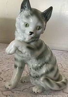 front view of porcelain gray tabby cat figurine with raised paw