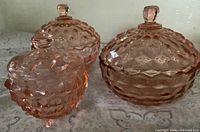 Three pink depression glass lidded dishes front view