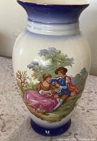Full view of white porcelain vase with cobalt blue rim and base, Fragonard scene visible