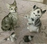 Front view of two adult cat and two kitten figurines