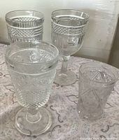 Four vintage clear glasses grouped: two Libbey Diamond Point goblets, one floral band goblet, one Imperial Cape Cod tumbler