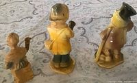 Rear view of all three figurines showing paint and molded bases