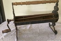 Full view of log roller showing handle, crank and overall structure