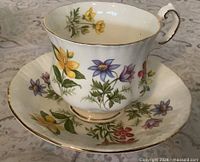 Front view of teacup on saucer showing pattern and gold trim