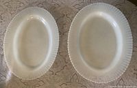 Top view of both oval milk glass platters showing size and rim design