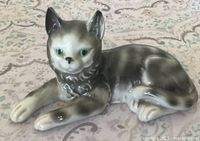 Front view of porcelain gray tabby cat figurine showing facial detail and green eyes