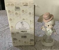 Front of original box with product label and figurine displayed beside it