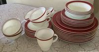 Stacked Pyrex Royal Burgundy dinnerware pieces showing plates, cups, bowls