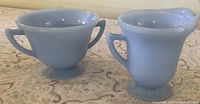 Side view of creamer and sugar bowl showing shape, color and handles