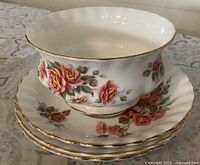 sugar bowl stacked on three saucers, showing floral pattern and gold trim