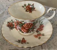 Cup on saucer showing floral design and gold trim