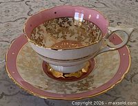 Teacup on saucer showing pink white gold floral design