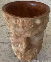 Front view showing sculpted face and marbled stone