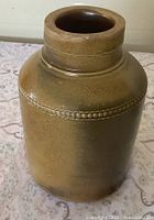 Overall view of glazed stoneware jar showing beaded rim and color