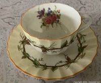 Teacup on saucer showing pattern, colours, fluting