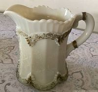 Front and side view showing relief design, scalloped rim and gold accents